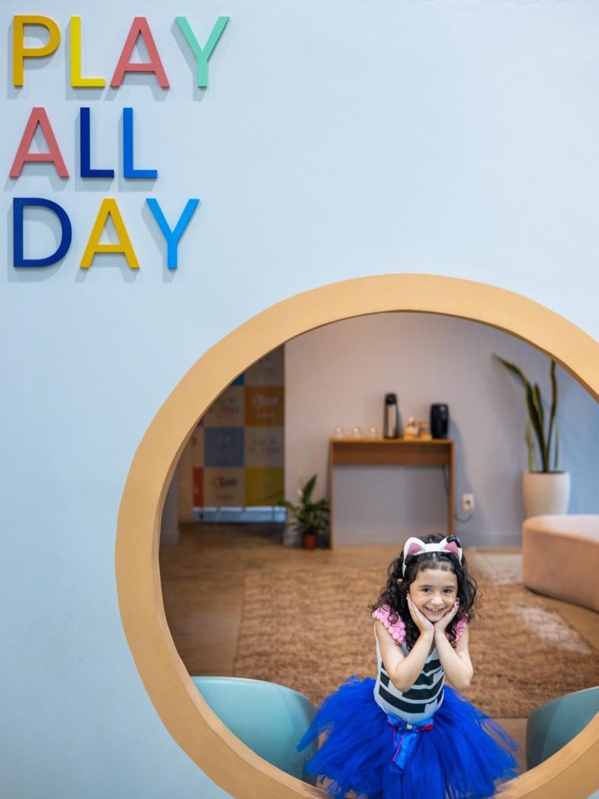 Hall de entrada com o letreiro Play All Day e arco espelhado