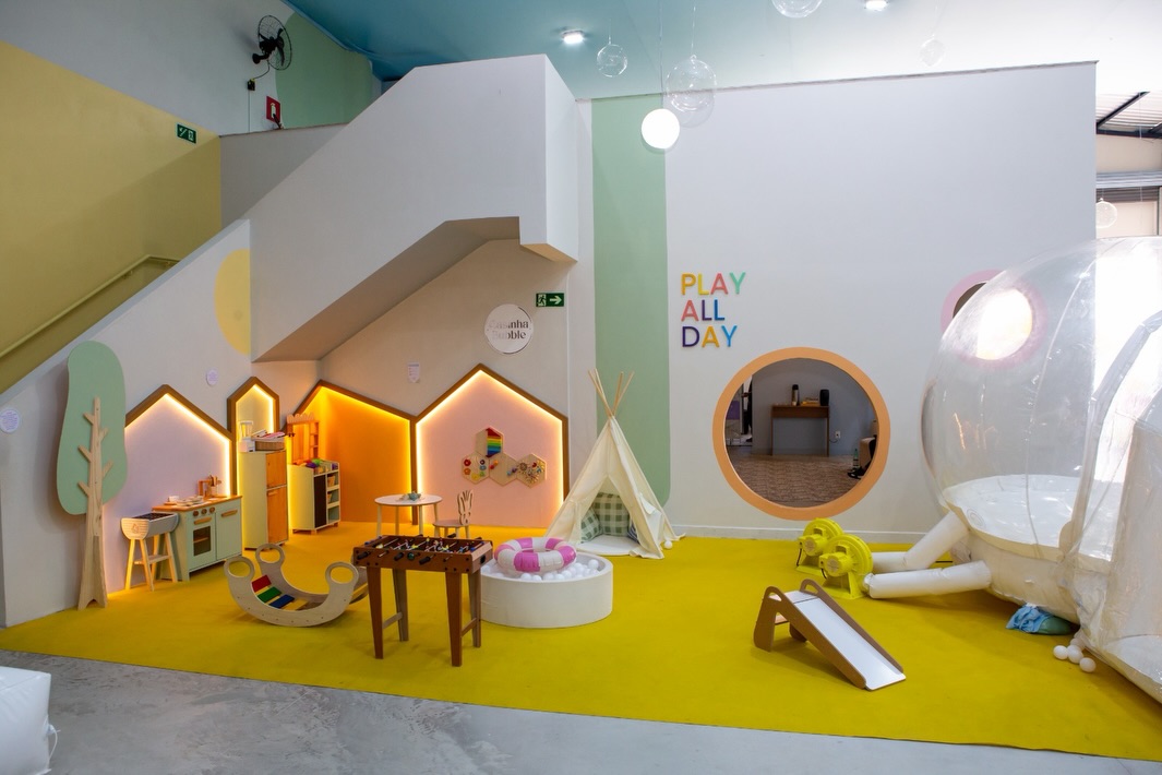 Visão geral da brinquedoteca Play All Day com casinhas, tenda e Bubble House inflável