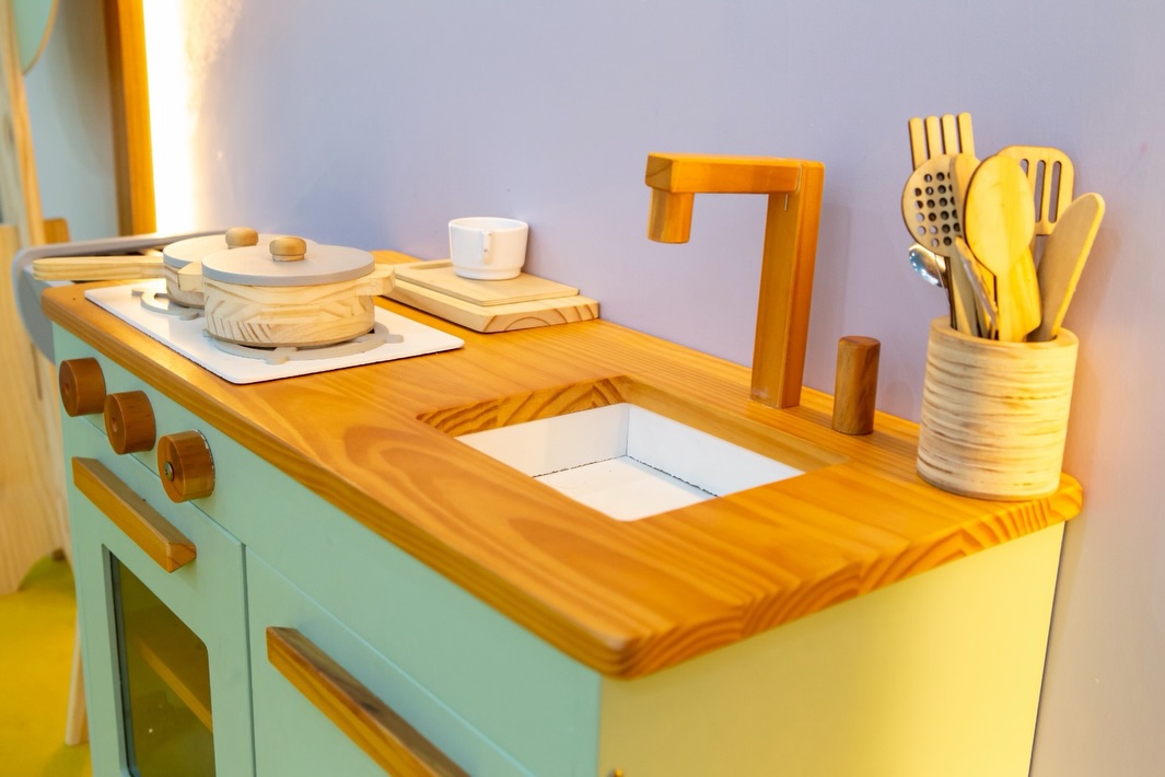 Cozinha infantil de madeira com pia, utensílios e fogão