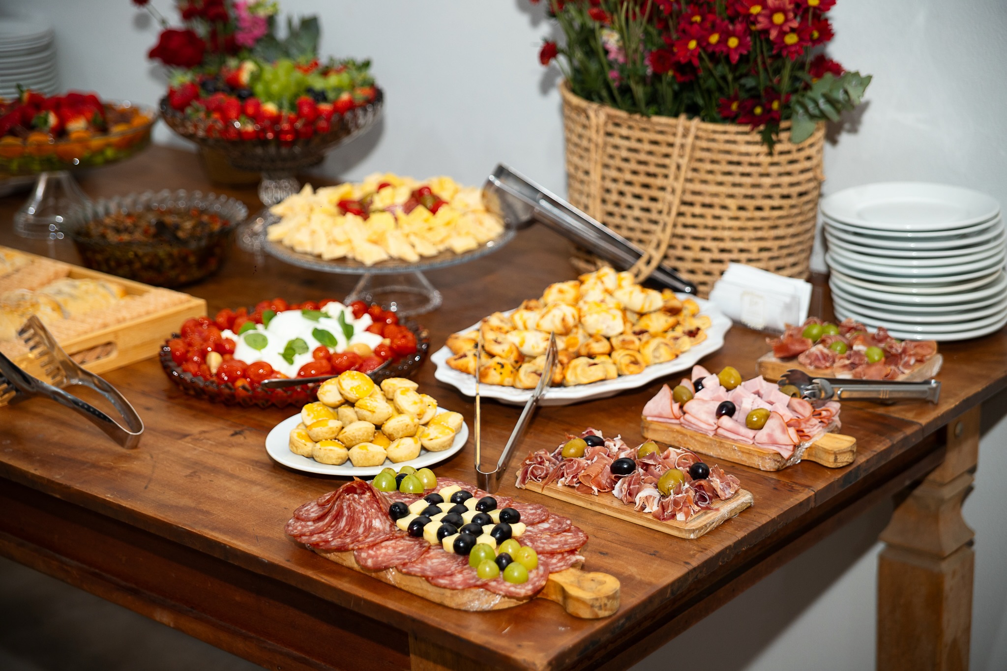 Mesa de buffet servida com salgados, frios e doces