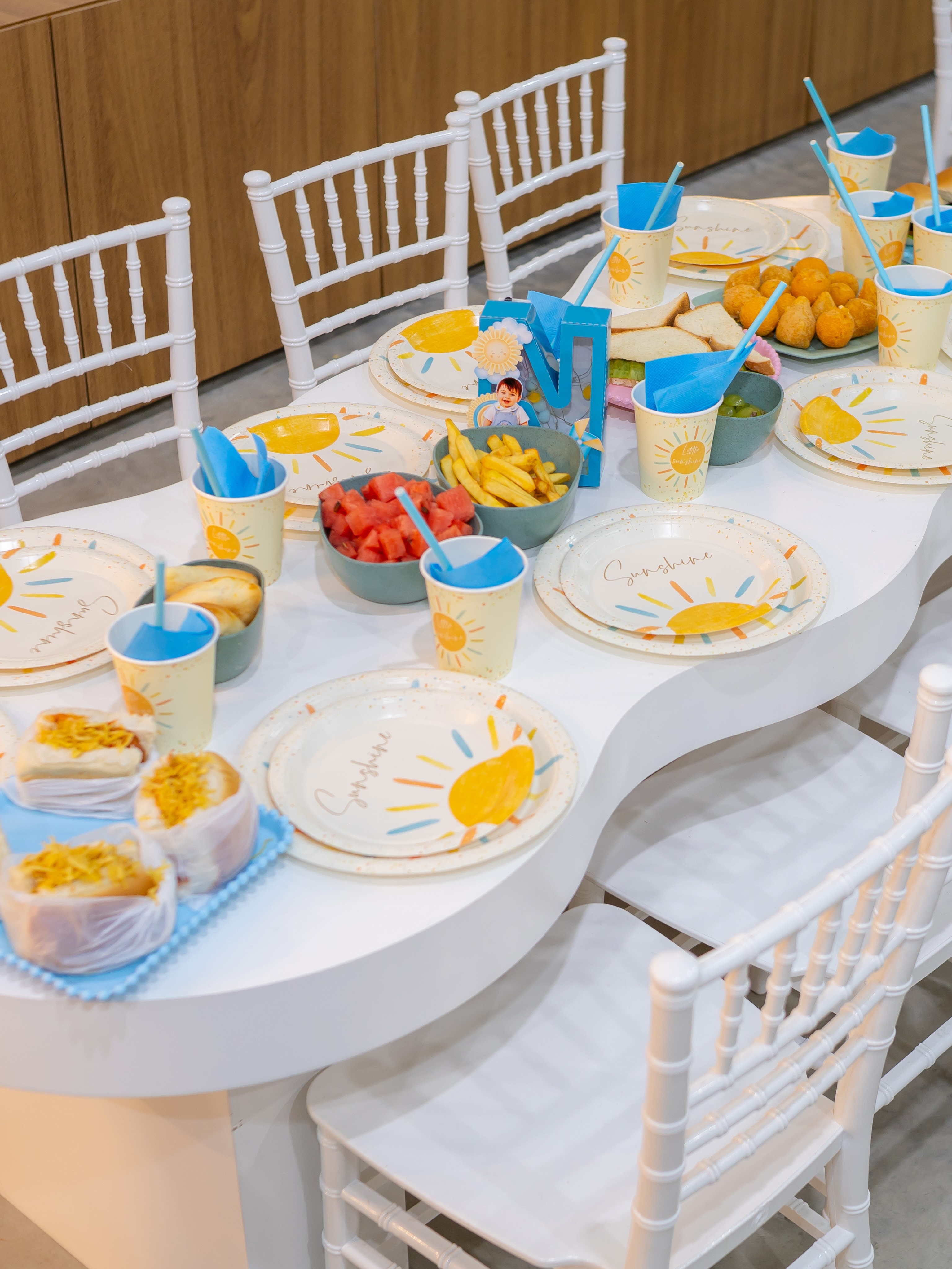 Mesa posta em tons de azul com toalha, pratos e lembrancinhas